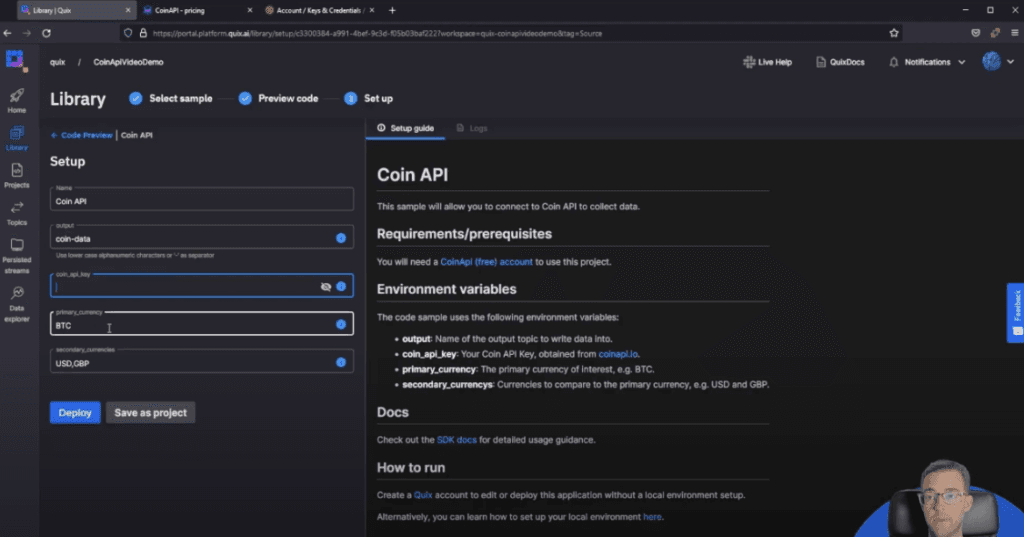 A web interface for setting up the Coin API in a development environment. The left side shows input fields for configuring the API, including name, output, API key, and currency options. The right side displays setup instructions, requirements, and environment variables. The interface includes options to deploy or save as a project. A small profile picture of a man with glasses is visible in the bottom right corner.